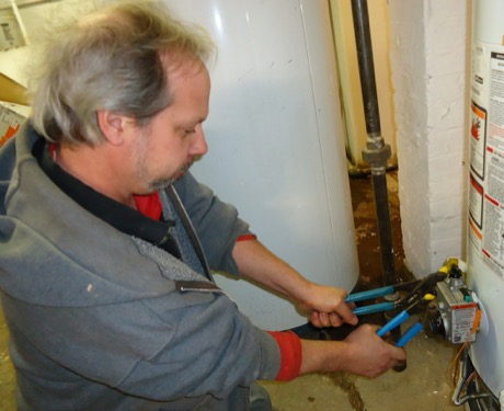 A plumber tightening a pipe joint